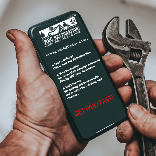 A smartphone displaying the MRC Restoration plumber referral program details held by a hand next to a wrench emphasizing the steps to refer evaluate and get paid fast