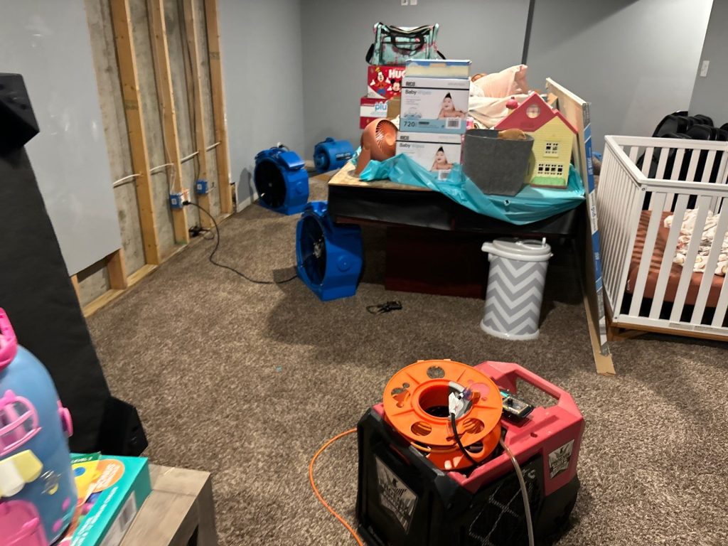 A flooded basement in Farmington Missouri with water saturated carpet and visible water damage to walls and ceiling