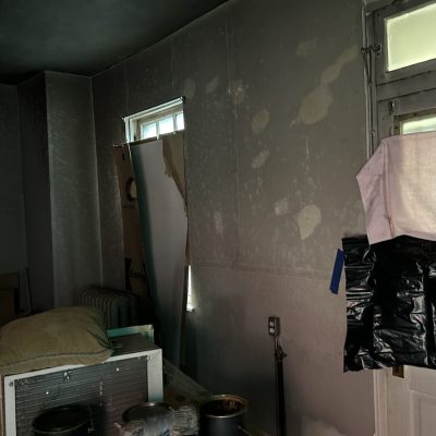 Soot and Smoke Cleanup in a room with extensive soot and smoke damage on walls and ceiling.