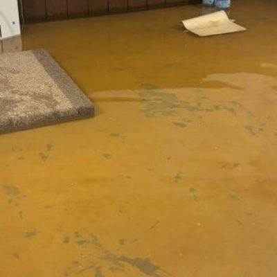 Room with flooded floor and visible water damage.