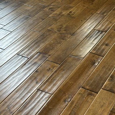 Close-up of hardwood flooring with visible water damage caused by a leaking dishwasher