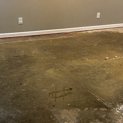 Flooded concrete basement floor with visible water accumulation.